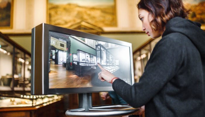 A woman in the museum uses the touchscreen monitor electronic guide, the concept of modern education A woman in the museum uses the touchscreen monitor electronic guide, the concept of modern education